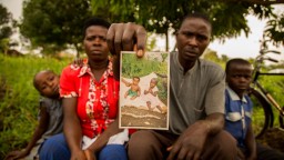 Edith and Mazima holding photo of Asha