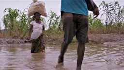 Two people wade through flood water