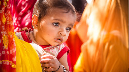 A baby looking over its mother