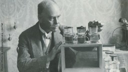 Black and white photo of Sir Ronald Ross with his microscope