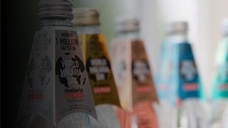 Lineup of tonic water bottles from Fever Tree Mixers featuring a Malaria No More campaign