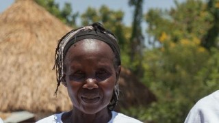 three people in the sunshine looking at the camera