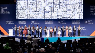 Young people stand on stage at the Kigali Summit on Malaria and NTDs